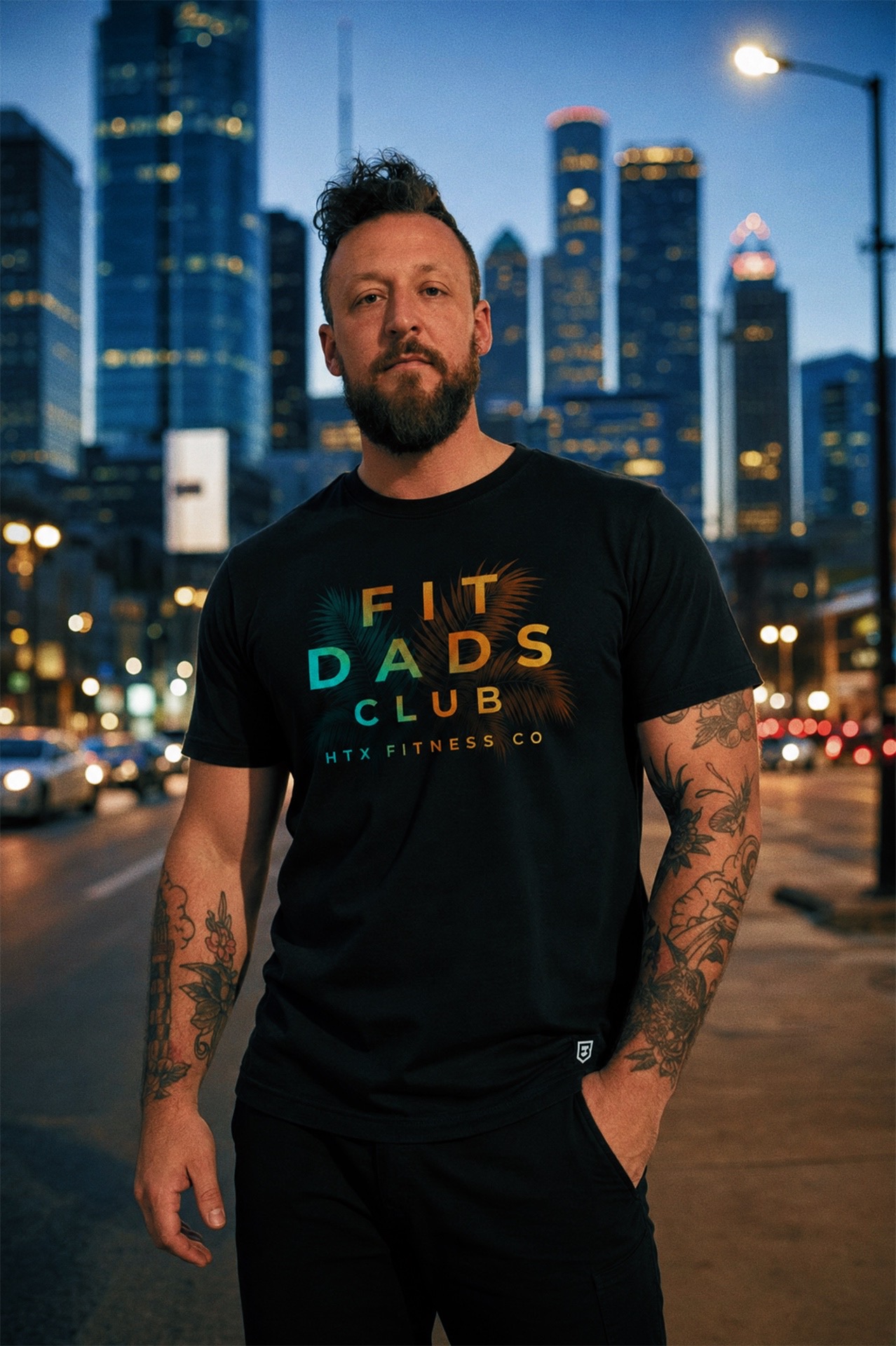 Model wearing an HTX Fitness Co. tee on a downtown Houston street at blue hour
