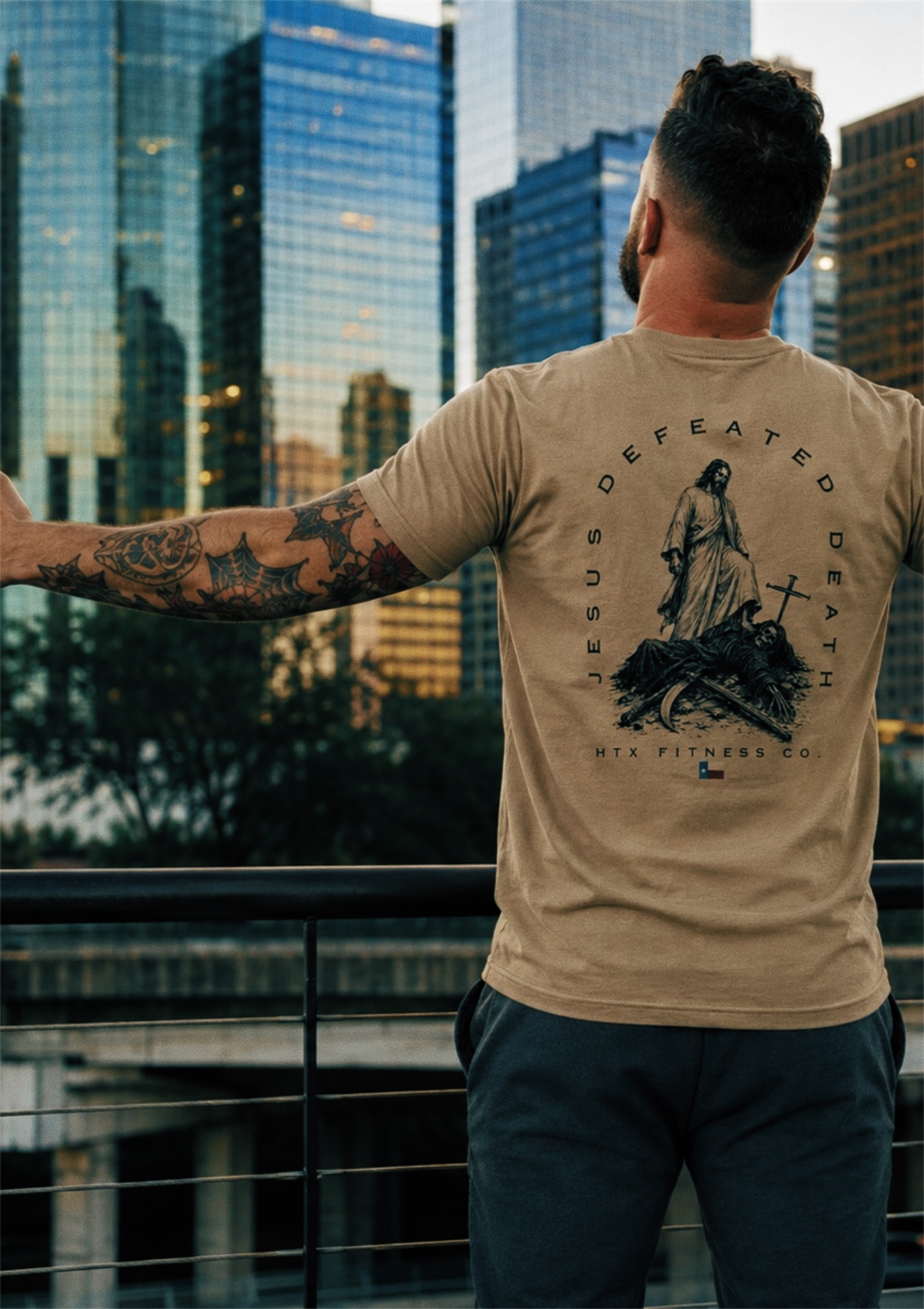 Model wearing the Defeated Death Tee with the Houston skyline behind him